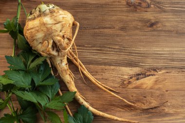 Açık kahverengi ahşap yüzeyde yaban havucu kökü.