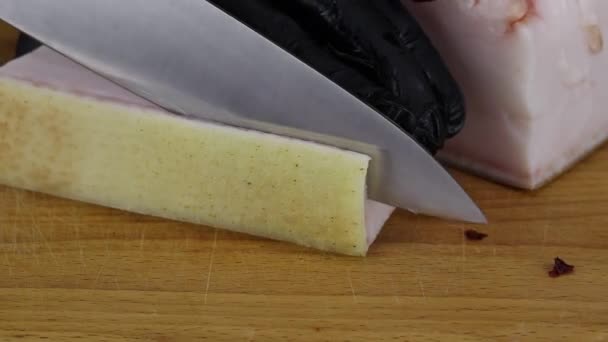 A chef cuts a thick crust from a large piece of lard — Stock Footage Chef Cuts Thick Crust Large Piece Lard Video Clip