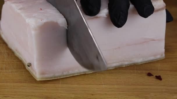 A chef cuts with a large knife a large piece of salted pork lard — Stock Footage Chef Cuts Large Knife Large Piece Salted Pork Lard Stock Video