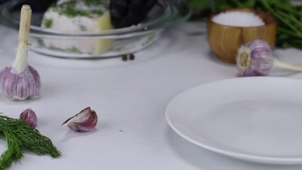The chef soaks in salt, garlic and chopped dill a large piece of pork fat and puts it on a white plate — Stock Footage Chef Soaks Salt Garlic Chopped Dill Large Piece Pork Fat Stock Footage