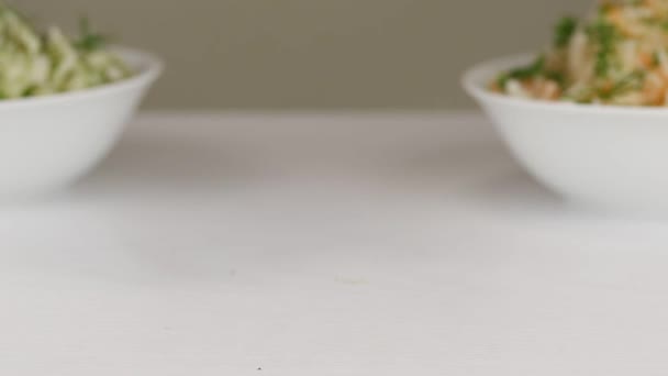 女人在白色的表面放上一个白色的碗 里面放着发酵的卷心菜和绿葱甜菜 还有特写 — 图库视频影像