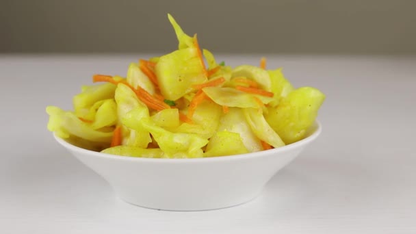 Chopped green onions are added to a white bowl with fermented cabbage and carrots with curry seasoning, close-up — Stock Footage Chopped Green Onions Added White Bowl Fermented Cabbage Carrots Curry Royalty Free Stock Video