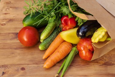 Kese kağıdında yeşil, sarı ve kırmızı sebzeler