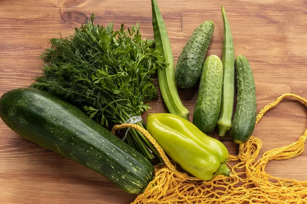 Verduras verdes junto a bolsa de hilo amarillo — Foto de Stock