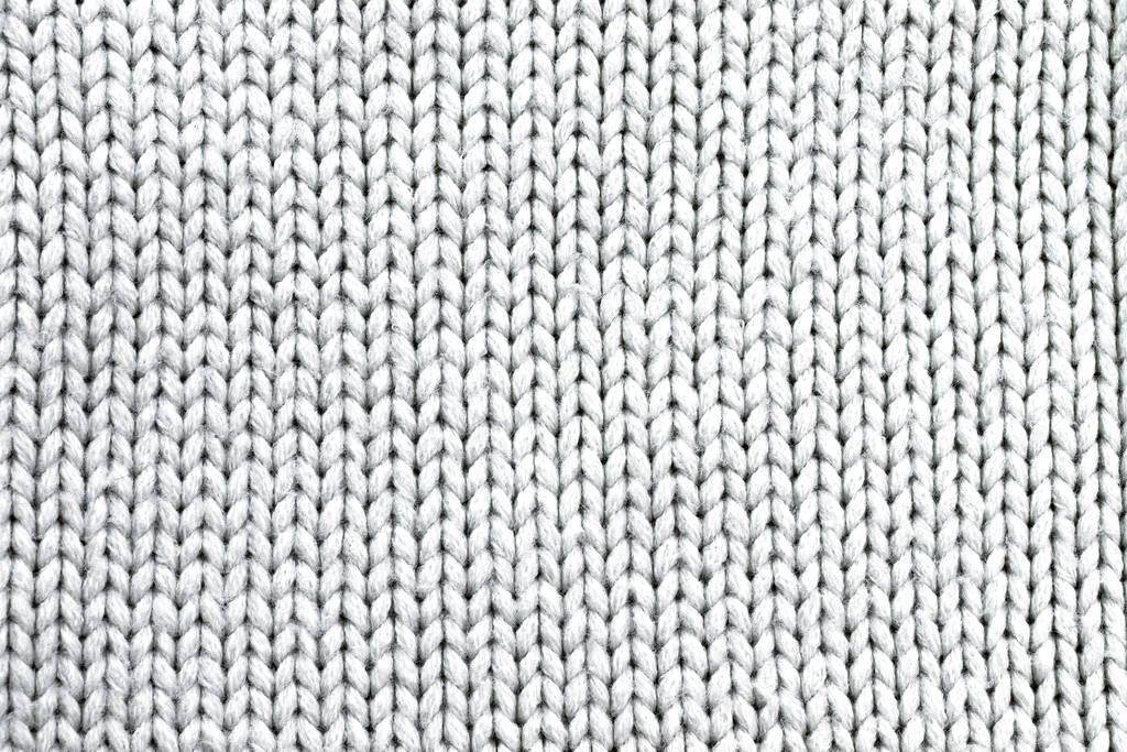Background in the form of a white knitted wool product