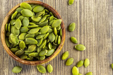 Kahverengi bir kasede kabak çekirdeği kabuğu soyulmuş.