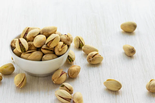 Fıstıklar beyaz cam bir kasede yatar.