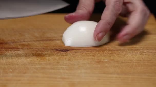 Frau Schneidet Weiße Zwiebel Mit Einem Großen Messer Auf Einem — Stockvideo