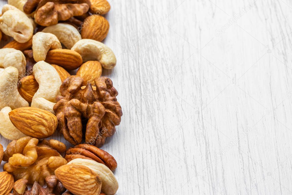Walnuts, cashews, almonds and pecans lie on the left