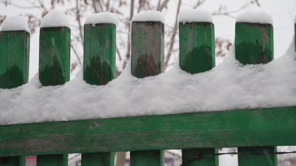 Neve Está Uma Cerca Madeira Verde — Vídeo de Stock