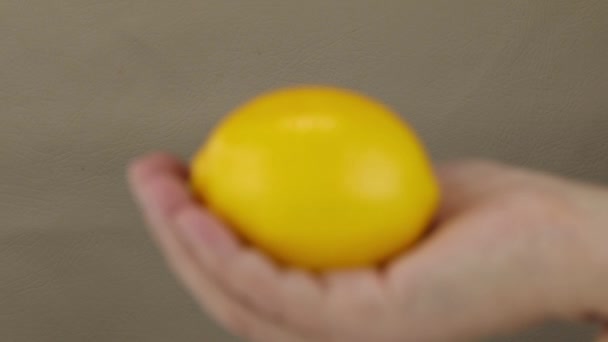 Câmera Mostra Uma Mão Feminina Com Limão Borrão Para Concentrar — Vídeo de Stock