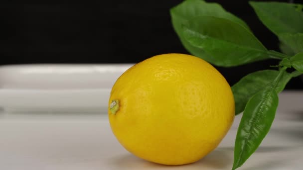 一只大柠檬躺在前排 母柠檬手将两只柠檬放在白盘上 — 图库视频影像