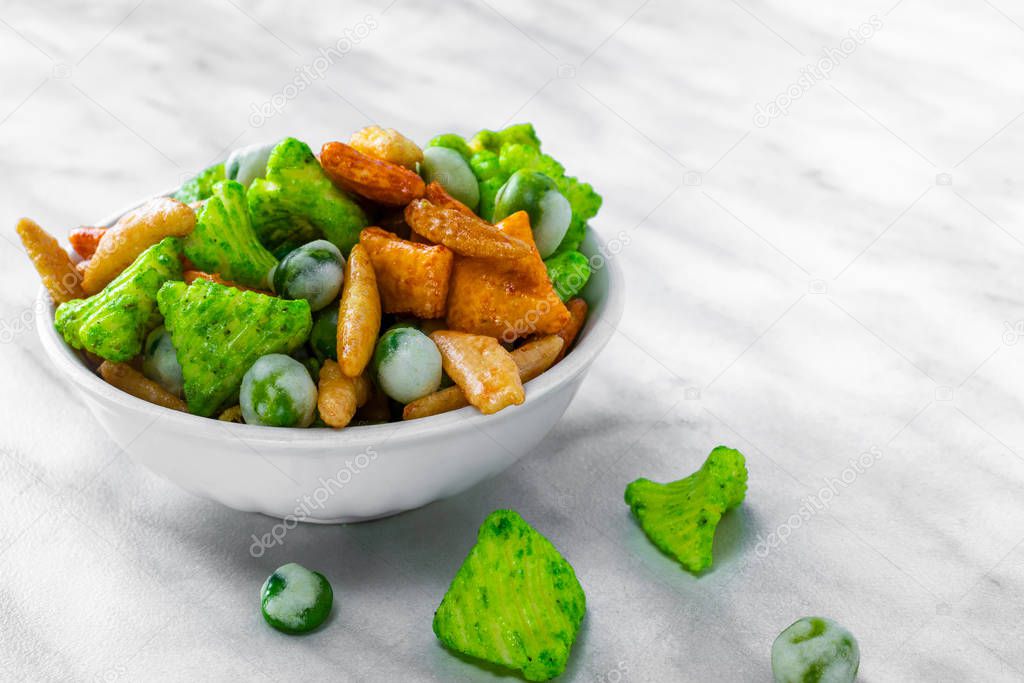 Japanese hot snacks with peanuts and wasabi lie in a white bowl 