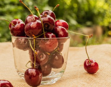 Olgun kiraz yapraklarıyla dolu şeffaf kupa