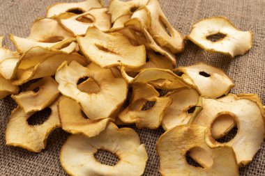 Yeşil elmadan yapılmış elma parçaları gri çuval bezinin üzerinde duruyor.