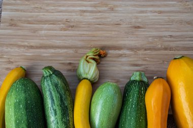 Yeşil ve sarı kabak kahverengi ahşap bir arka planda, yukarıda boş bir yer.