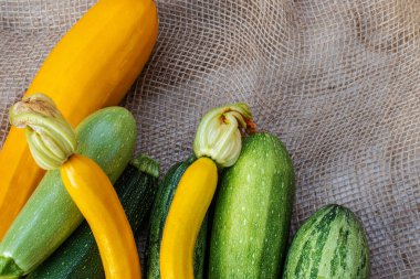 Yeşil ve sarı kabak gri bir çuval bezinin üzerinde yatıyor.