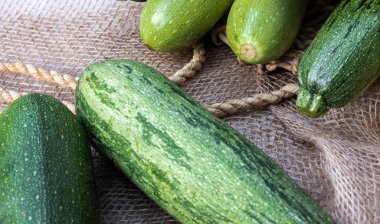 Gri çuval bezinin üstünde beş yeşil kabak.