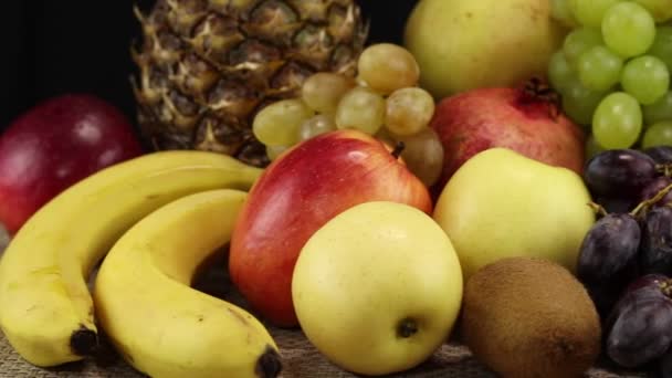 Una Gran Pila Diferentes Frutos Encuentra Una Superficie Gris Primer — Vídeo de stock