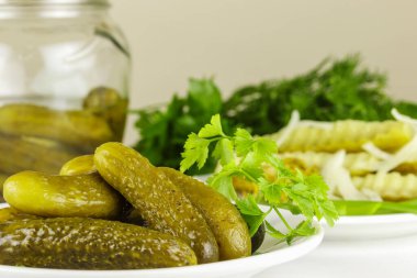 Beyaz bir tabakta mayalanmış salatalık yığını var.