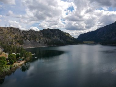Resimli Alta Gölü Eyalet Parkı 'nın muazzam hava fotoğrafları. İnanılmaz ve parlak mavi gökyüzü kümülüs bulutları yarı çöl arazisi ve Washington' daki dağlarla suya yansıyor.