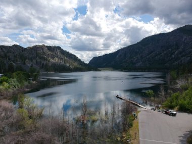 Resmedilmeye değer Alta Gölü Eyalet Parkı 'nın muhteşem hava fotoğrafları. İnanılmaz ve parlak mavi gökyüzü kümülüs bulutları yarı çöl arazisi ve Pateros Washington' daki dağlarla suya yansıyor.