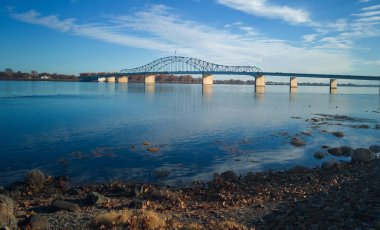 Kennewick-Pasco Washington 'da güneşli bir sabahta mavi gökyüzü ve bulutlarla Columbia Nehri üzerindeki tarihi mavi ve beyaz kemerli köprü.