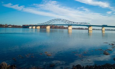 Historic blue and white arch truss bridge over the Columbia River with blue skies and clouds on a sunny morning in Kennewick-Pasco Washington clipart