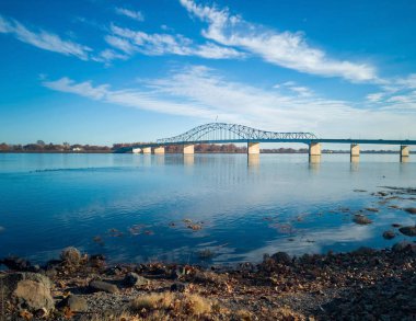 Kennewick-Pasco Washington 'da güneşli bir sabahta mavi gökyüzü ve bulutlarla Columbia Nehri üzerindeki tarihi mavi ve beyaz kemerli köprü.