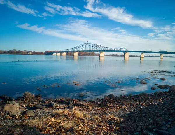 Kennewick-Pasco Washington 'da güneşli bir sabahta mavi gökyüzü ve bulutlarla Columbia Nehri üzerindeki tarihi mavi ve beyaz kemerli köprü.