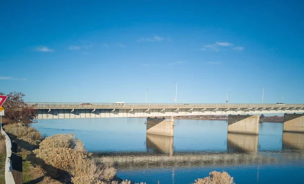 歴史的な青と白のアーチは ケンニウィック パスコ ワシントンで晴れた朝に青い空と雲を持つコロンビア川に架かる橋を横断しています — ストック写真