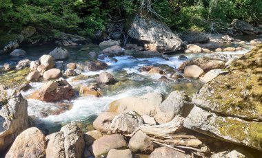 Shimmering cascades and bountiful boulders on the North Fork Sauk River in the Summertime off the Mountain Loop Highway in Silverton Washington State Snohomish County clipart