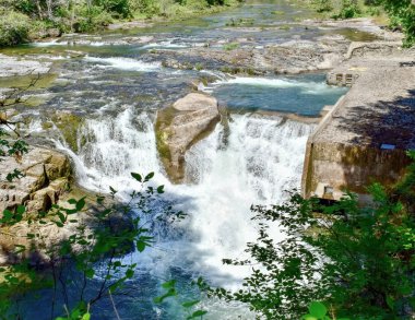 Majestic Steamboat Falls ve Kuzey Umpqua Ulusal Ormanı 'nın balık merdivenleri baharda Güney Oregon' daki Douglas County dağlarındaki mavi bir drenajdan fışkırıyor. 