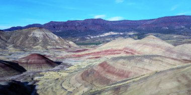 Renkli John Day Fosil Yatakları Oregon 'da yarı çöl manzarasında kırmızı yeşil turuncu ve sarı çizgili tepeleri boyadı.