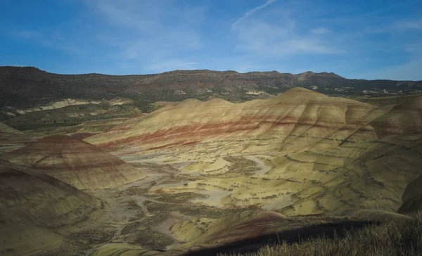 カラフルなジョンの日を息をのむ化石ベッドは オレゴン州の半砂漠の風景の中に赤い緑の黒いオレンジと黄色の縞で丘を描いた — ストック写真