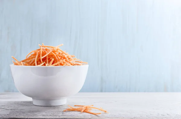 Shredded carrot in white ceramic bowl — Stock Photo, Image