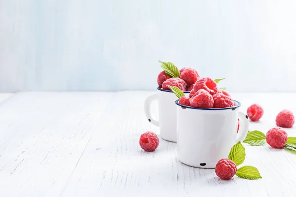 Fresh raspberries in   mugs — Stock Photo, Image