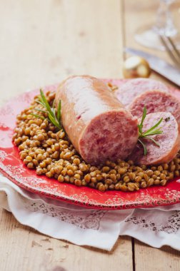 Italian large pork sausage cotechino served  with lentils. clipart