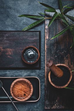 Cilt bakımı. Maske ve ovalama malzemeleri aktif kömür tozu ile koyu ahşap masa üzerinde, boşluk kopyala.