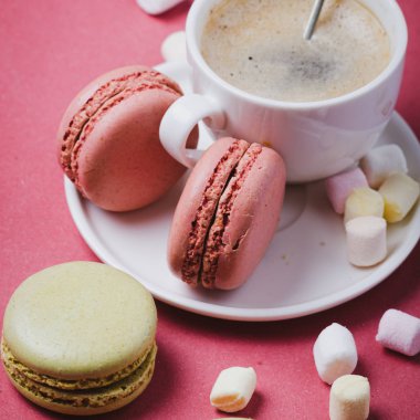 Bir fincan kahve ve makaron. Renkli pembe arkaplan.