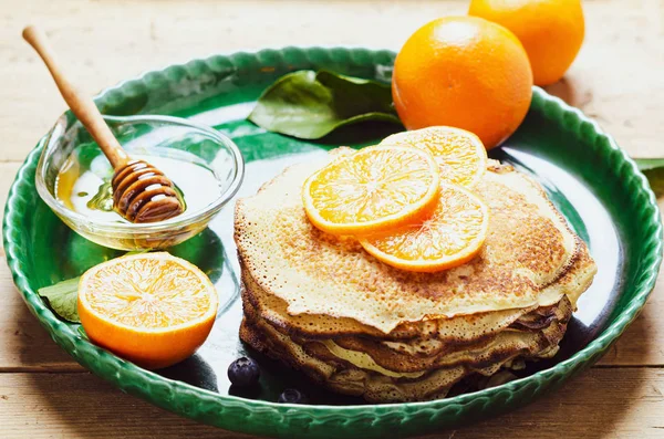 Pila de panqueques con naranja y arándanos y jarabe de miel . —  Fotos de Stock