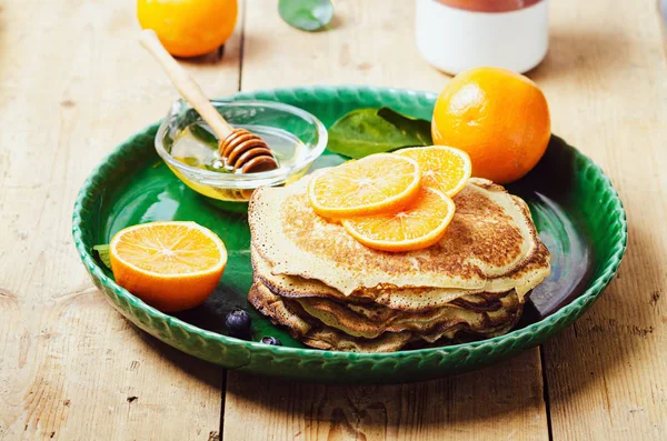 Pila de panqueques con naranja y arándanos y jarabe de miel . —  Fotos de Stock