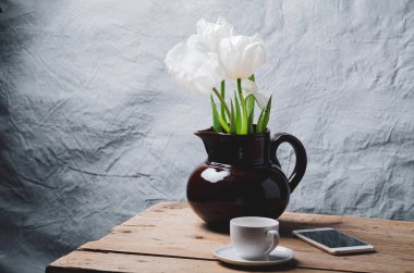 Ahşap masada seramik vazoda lale çiçekleri ve metin için yer var..