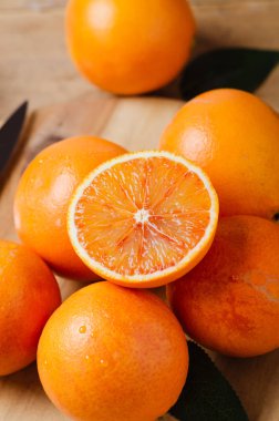 Tahta masada yeşil yapraklı taze portakallar..