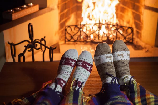 暖炉の近くの暖かい靴下の男と女 熱い飲み物とカップ ハート — ストック写真