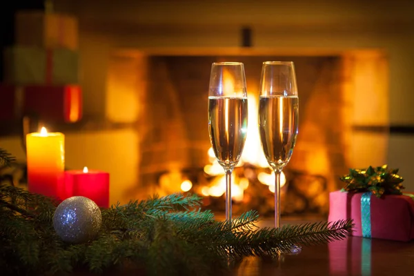 stock image New Year. Fireplace. Two wine glasses with champagne.