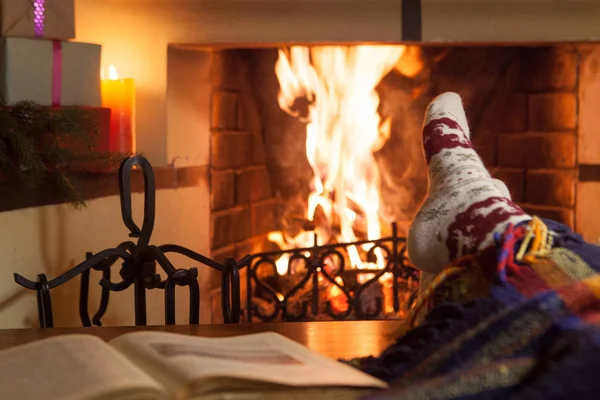 stock image Man and woman in warm socks near the fireplace. Cup with a hot drink. Heart.