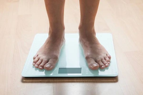 The legs of a young woman on the scales. Weight check. The concept of losing weight.