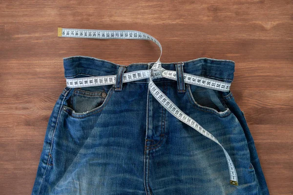 Ölçüm bandıyla kot pantolon. Kilo verme konsepti