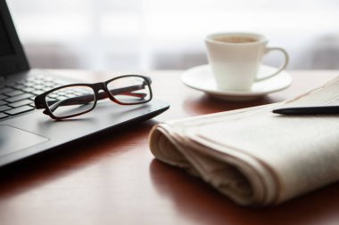 Masada bilgisayar olan bir gazete. Kahve molası.